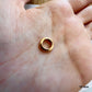 Éclat et proportion d'un petit fermoir rond en or rouge massif 18 carats pour création artisanale.