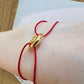 Bracelet cordon rouge porte-bonheur avec un graine de café en or 18 carats.